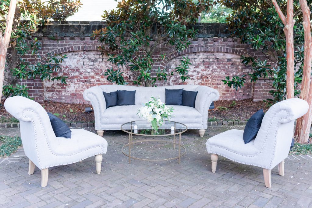 tufted couch and two chairs set up on outdoor courtyard patio