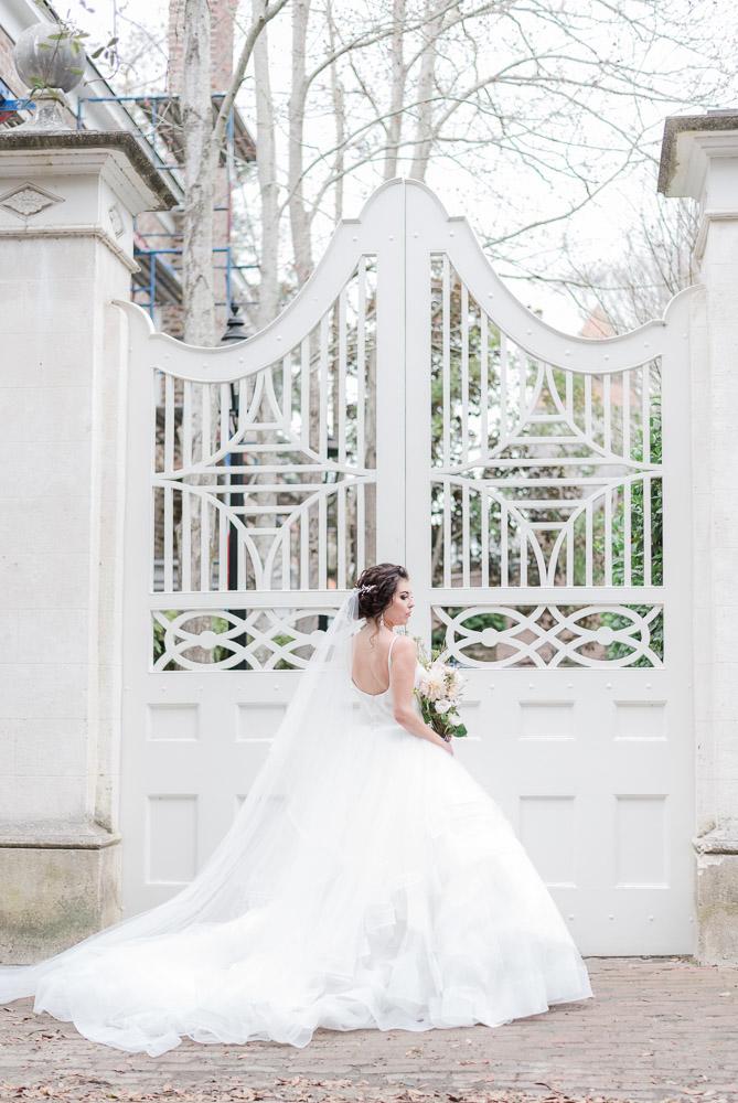 full length bridal portrait in front of white wooden gate