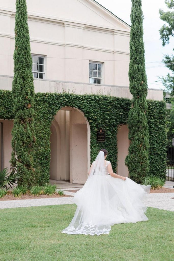 bride holding dress walking back into church
