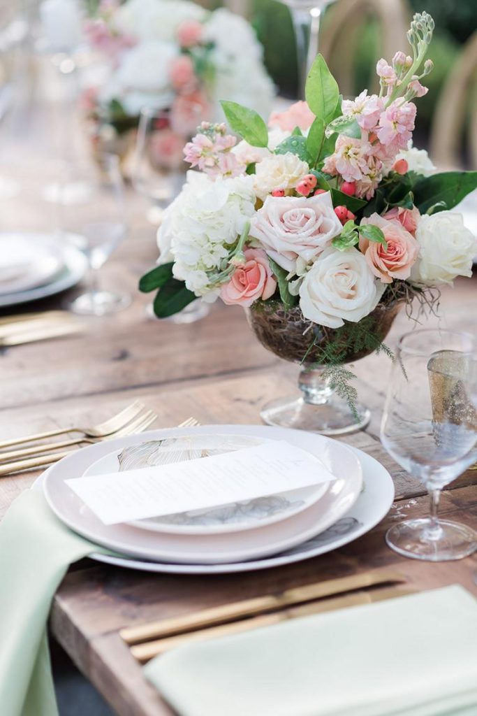 table place setting close up with vase of flowers
