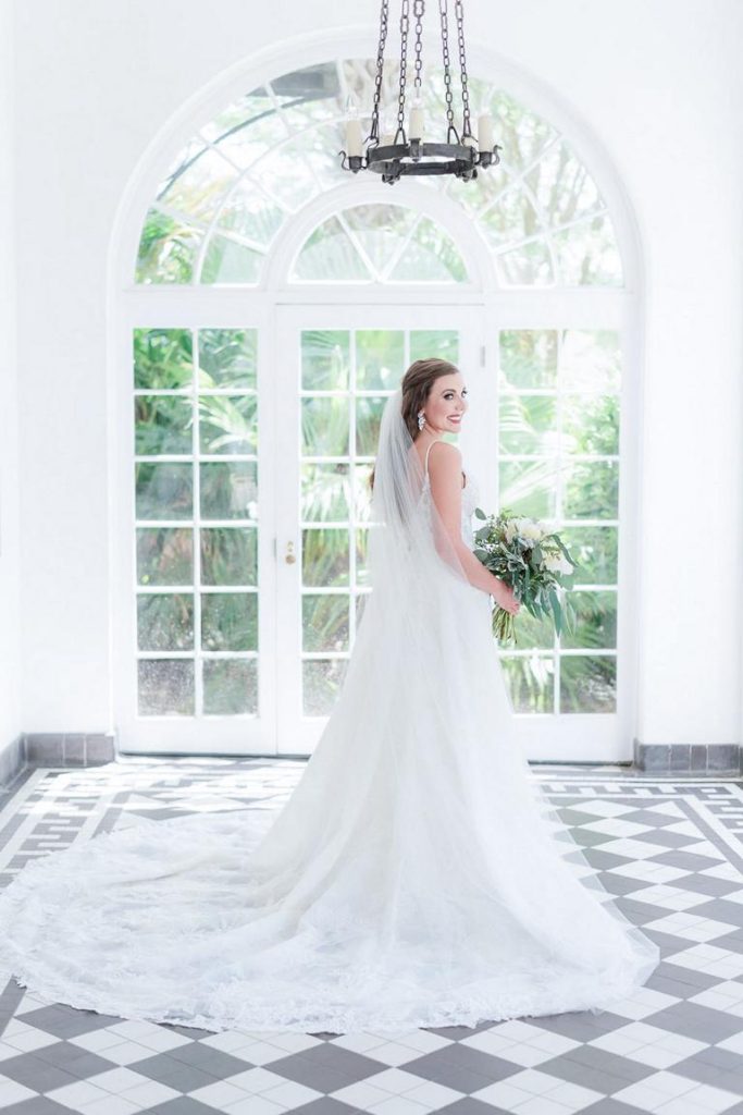 bride looking over shoulder downstairs at Lowndes Grove Portico