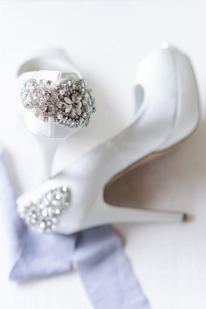 close up of bejewelled white wedding high heels