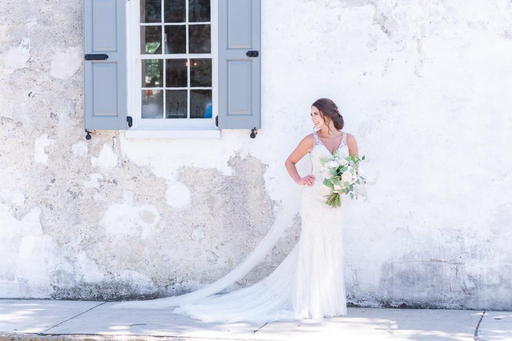bride looking over shoulder in front of peeling wall