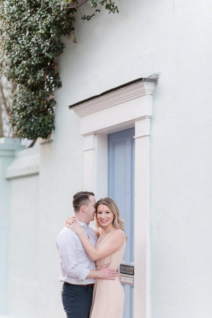girl with arm over fiancé's neck looks at camera