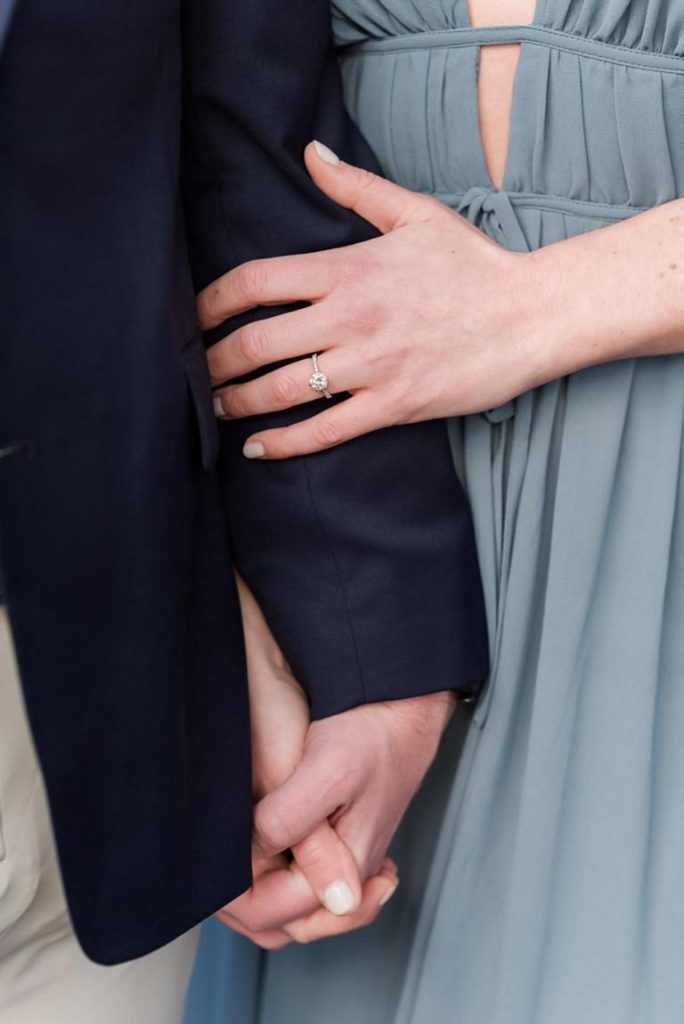 close up of engaged couple holding hands