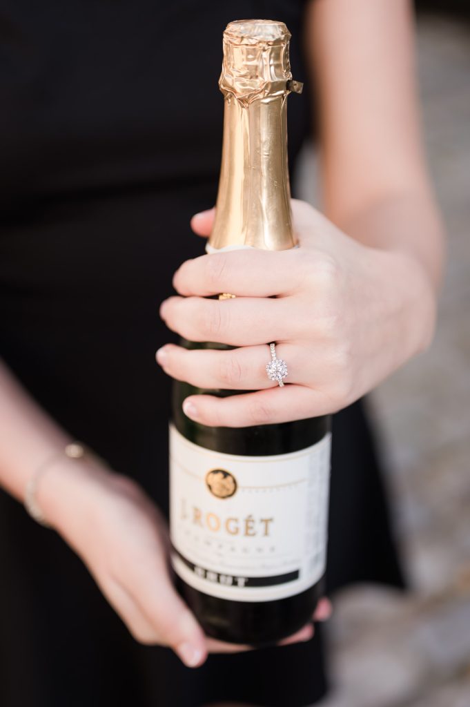 close up of engagement ring on champagne bottle