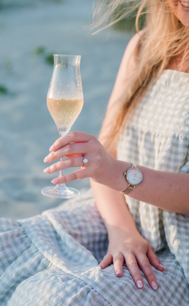 newly engaged bride holds a glass of champagne