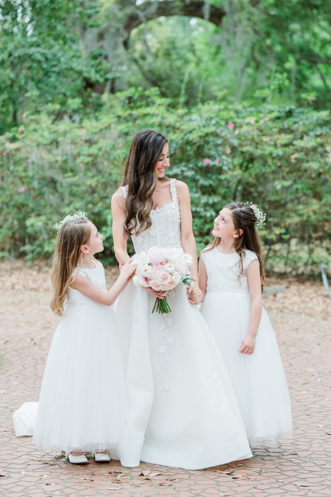 bride holding hands with two flower girls