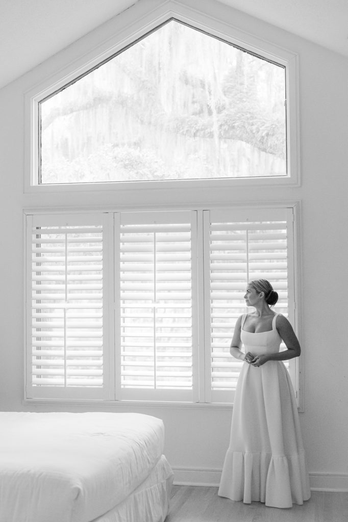 bride looking out window in wedding dress