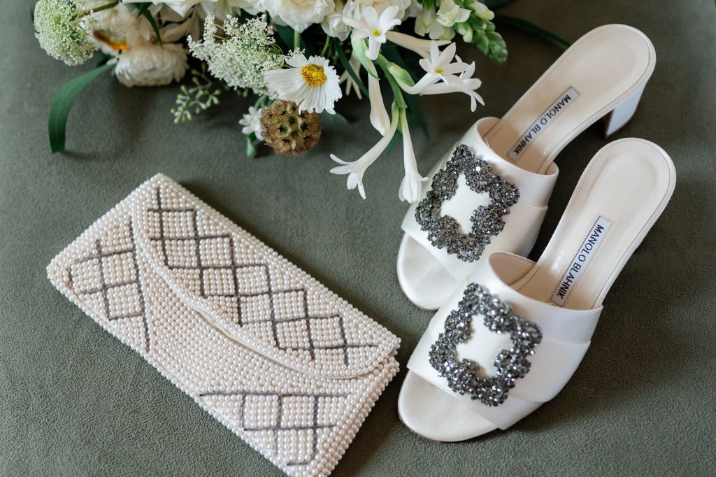 bride's Manolo Blahnik shoes, pearl beaded purse and floral arrangement