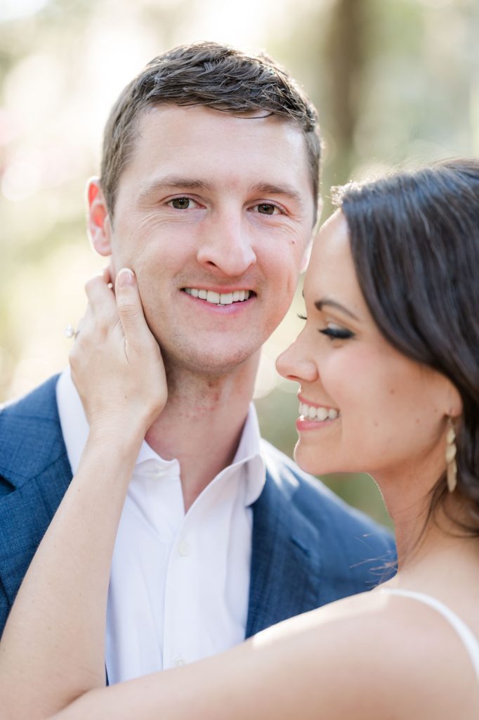 close up of girl cupping guy's face while he looks straight into camera