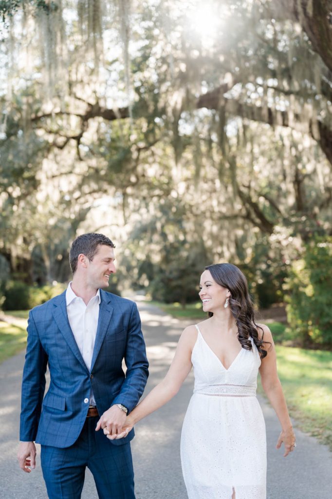 couple smile at each other while holding hands