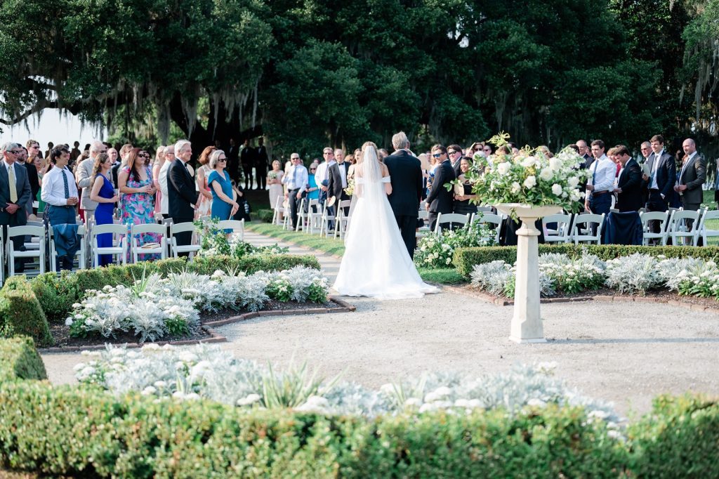 back of bride and father walking down aisle of wedding ceremony