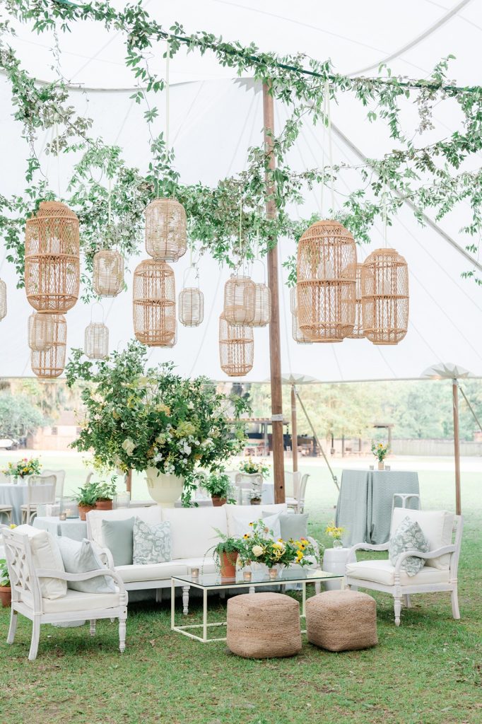 garden party themed outside wedding reception with floral, greenery, couches, chairs and ottomans