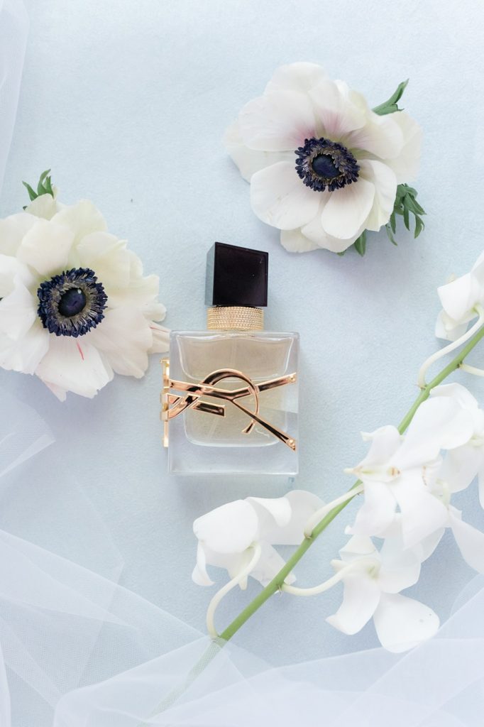 close up of YSL perfume bottle with flowers