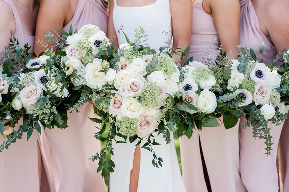 close up of bridesmaids and bride's bouquets of white and pink roses