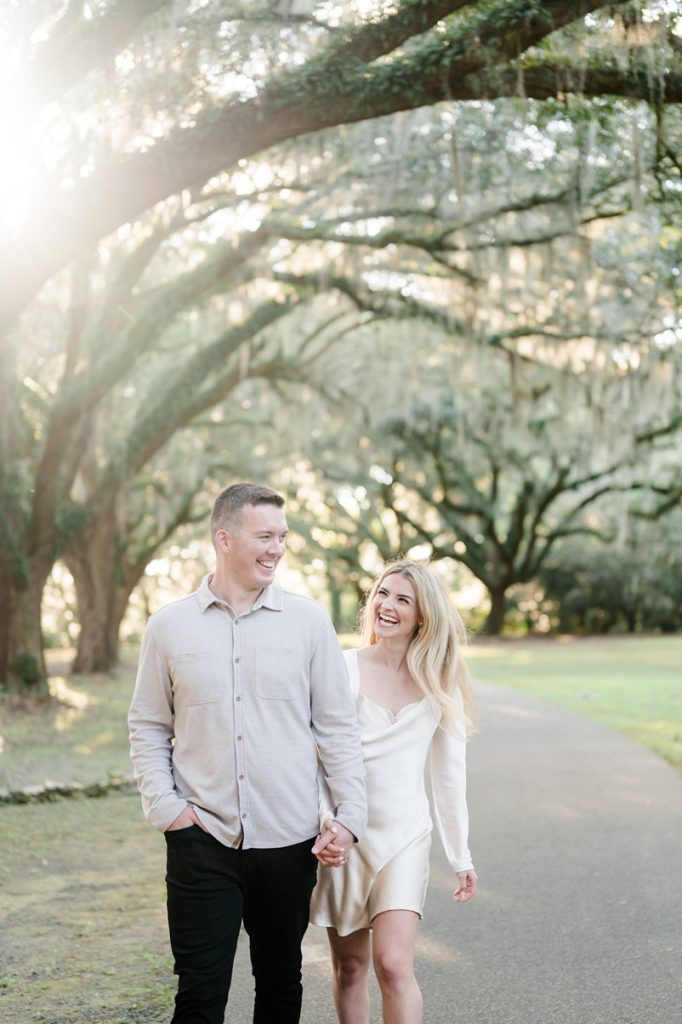 Couple walking down path holding hands and laughing