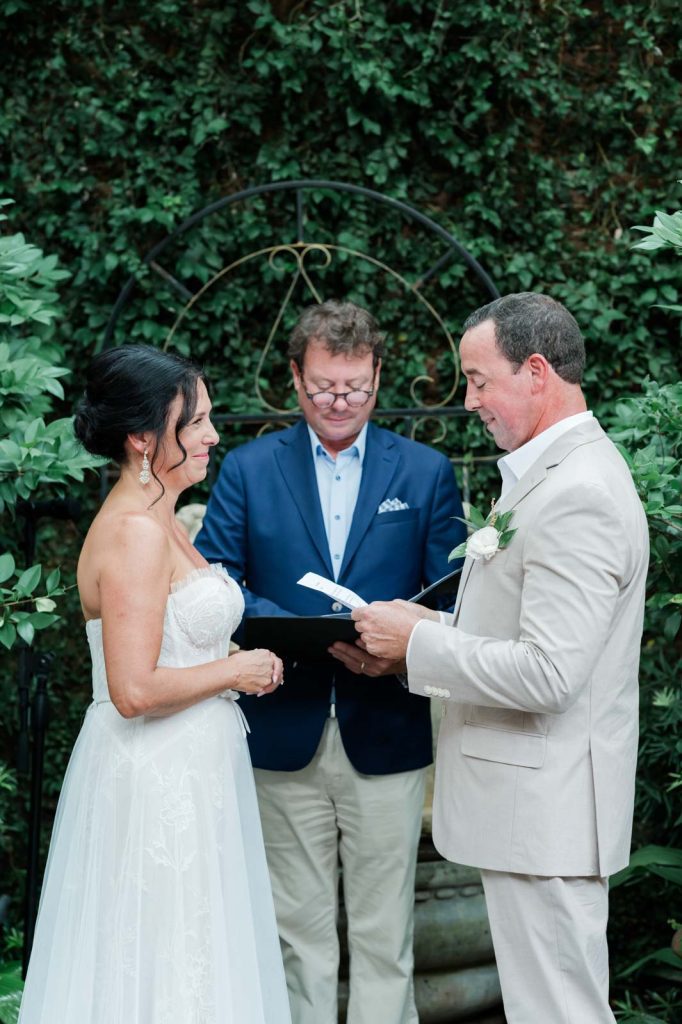 groom reading his vows at the altar to his bride