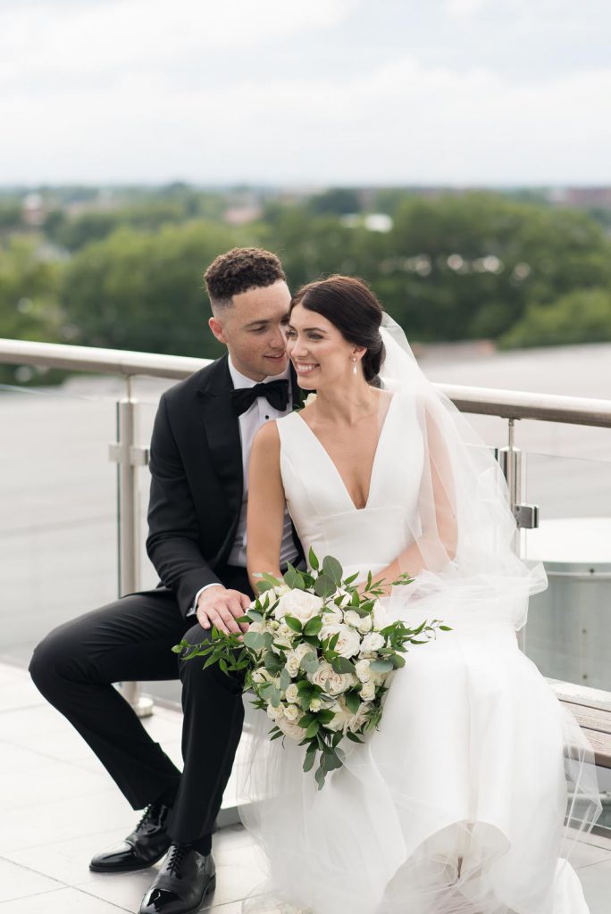 newlyweds sitting snuggled together looking off camera
