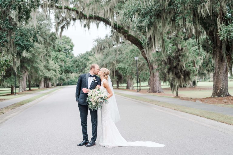 newlyweds kiss under oak tree with Spanish Moss at wedding venues Mount Pleasant