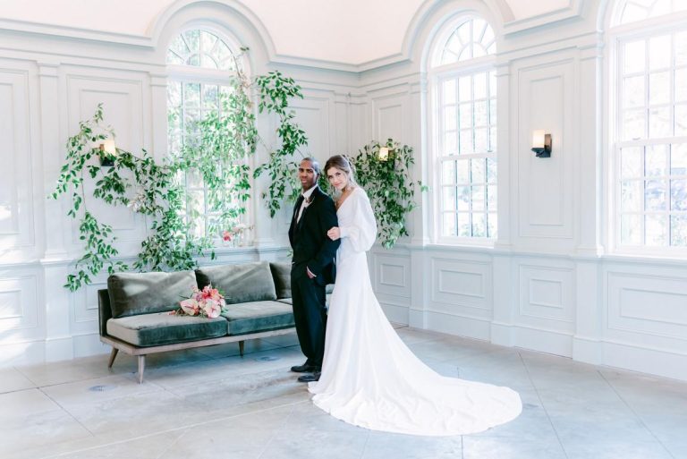 Newlywed couple stand inside I'on Chapel decorated with smilax greenery