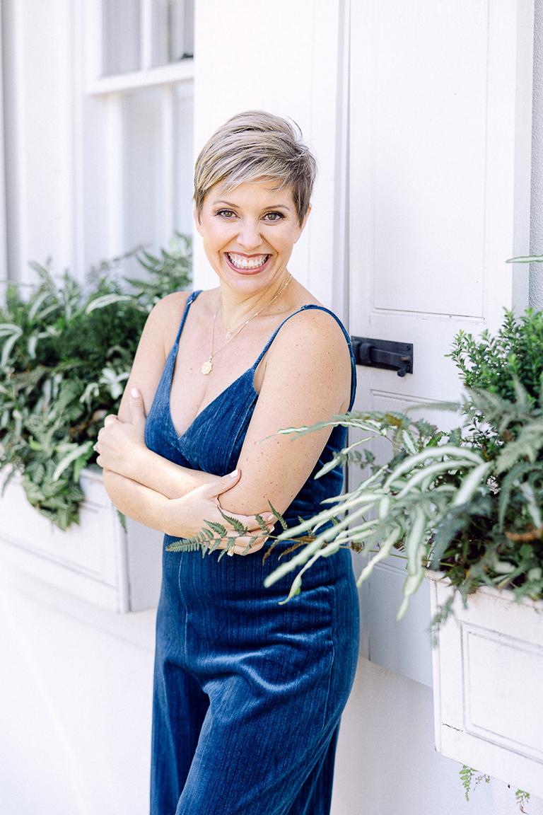 About Leigh Hayward, a Wedding Photographer in Charleston Leigh Hayward leans against white building