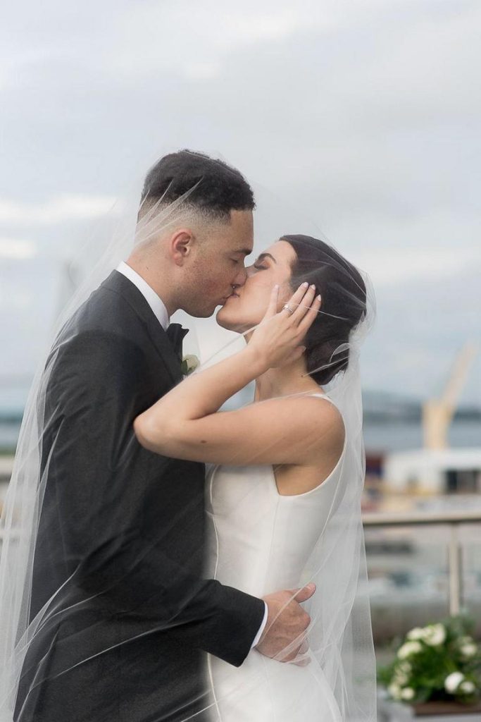 bride and groom kiss under veil on rooftop of Cedar Room