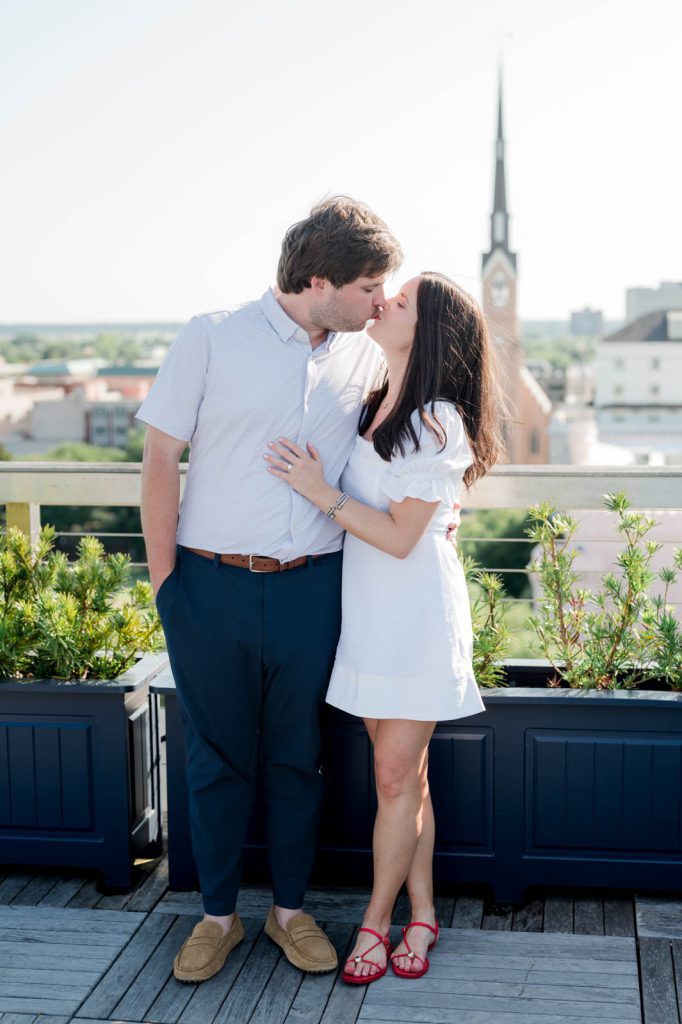 newly engaged couple share a kiss on the rooftop of the Dewberry hotel