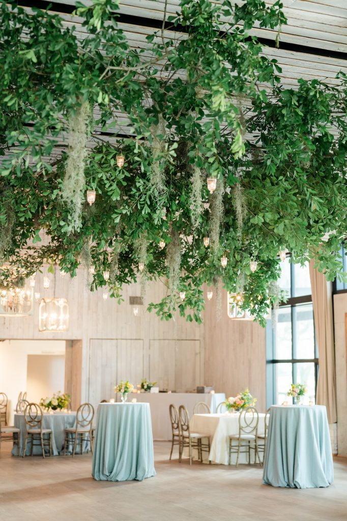 wedding reception with greenery and tealights hanging from the ceiling