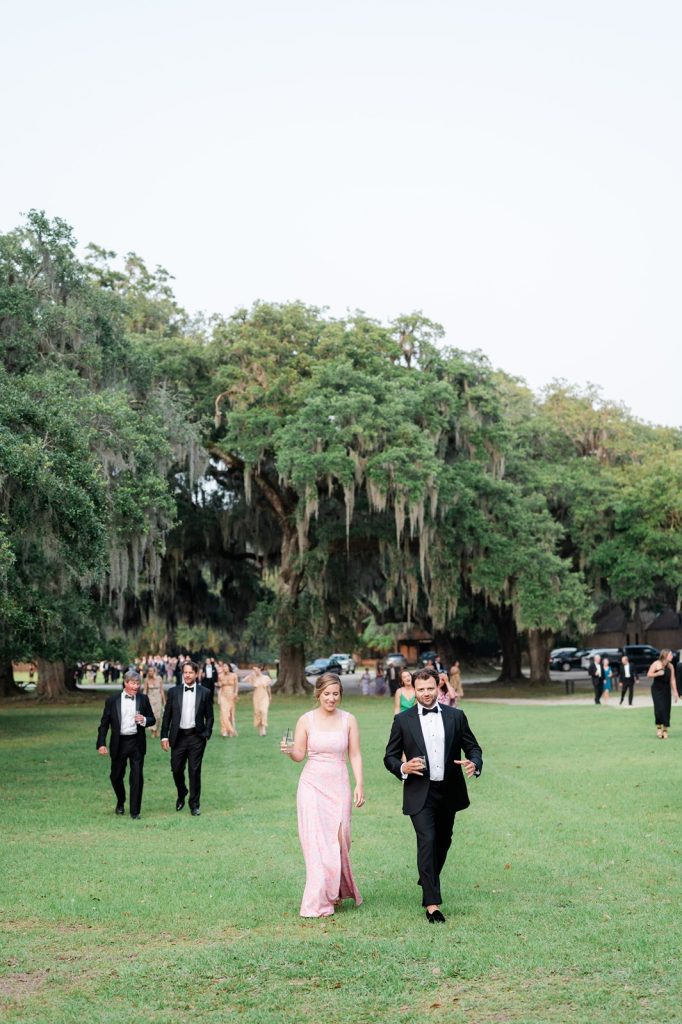 wedding guests walking across a lawn from cocktail hour to a wedding reception