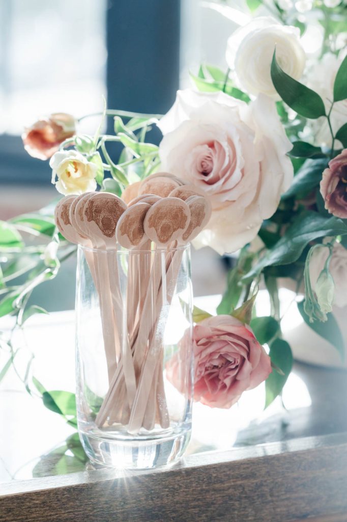 wooden drink stirrers with dog face printed on them displayed in a glass