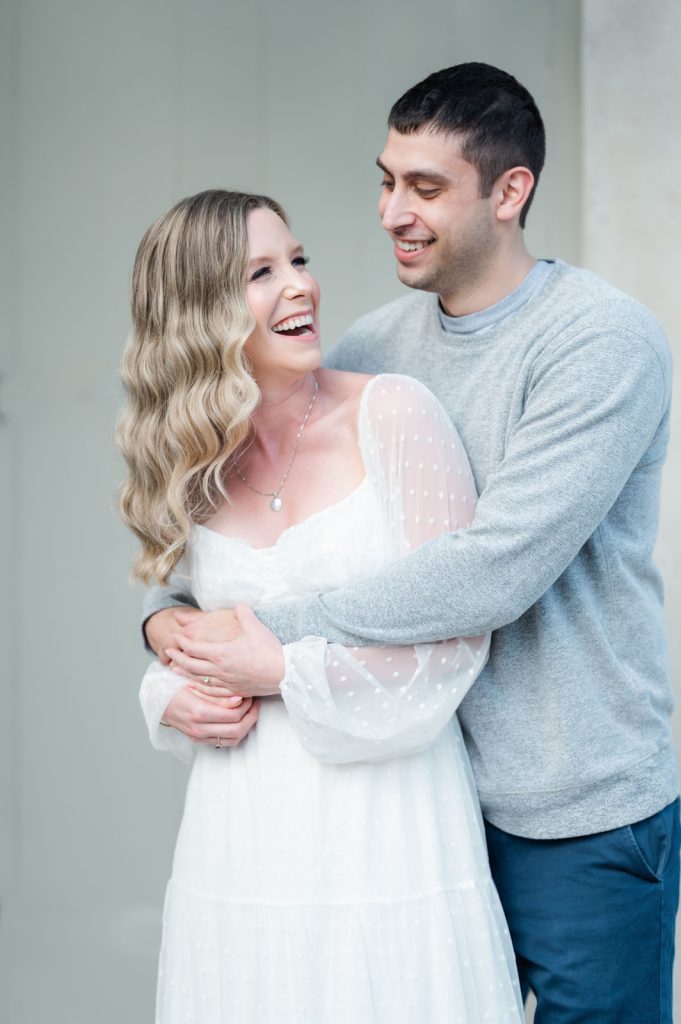 guy bear hugs girl from behind and makes her laugh