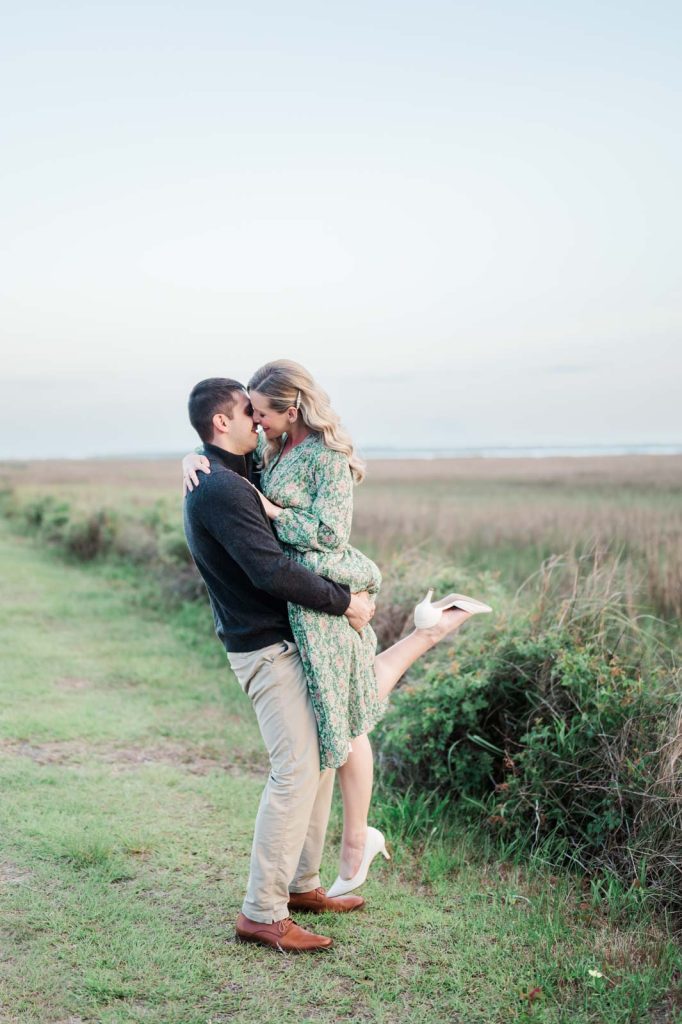 guy lifts girl up and kisses her in front of marsh